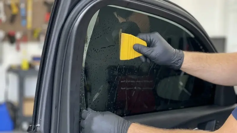 Window tint being applied to a vehicle